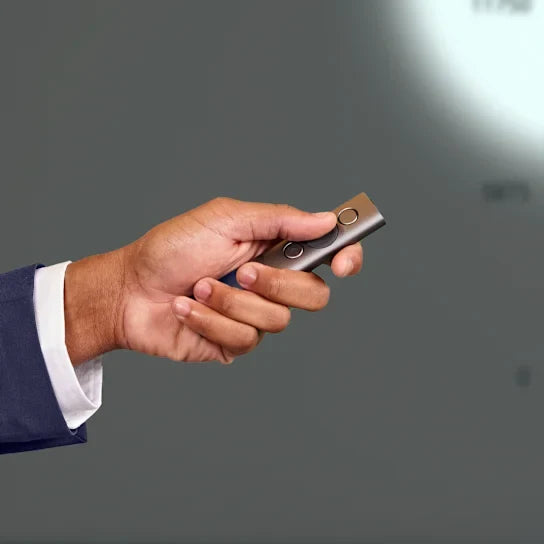 Hand holding a silver lighter against a gray background
