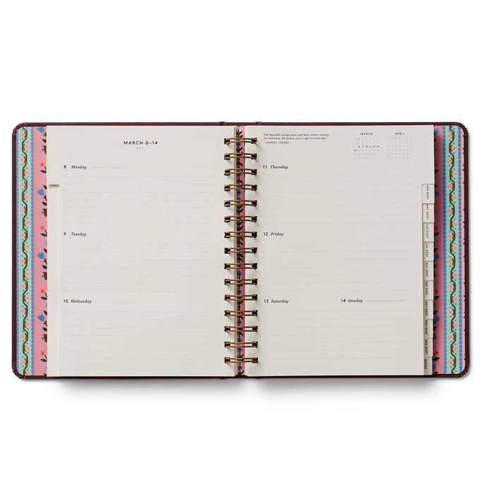Open planner with colorful spiral binding on a white background