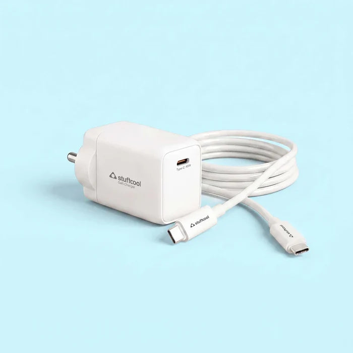 A white Stuftool USB-C fast charger with its matching USB-C cable coiled behind it, set against a solid light blue background.