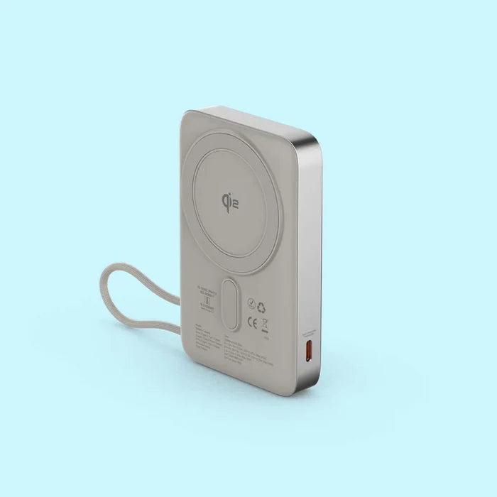 A silver portable power bank with a built-in wrist strap, featuring a Qi wireless charging pad on the back and a USB-C port on the side, set against a solid light blue background.